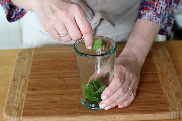 Echar las hojas de menta en los vasos