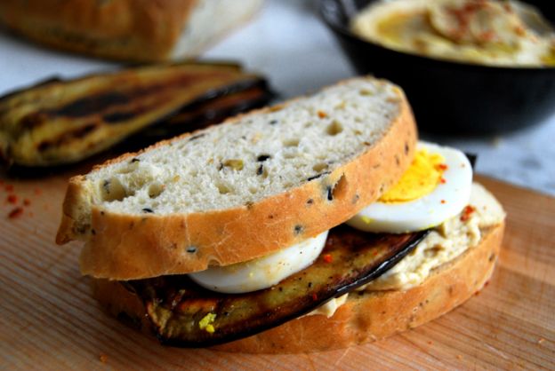 Sándwich de pan de pita con hummus, berenjena frita y huevo duro