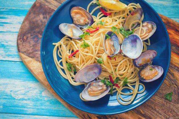 7. Añadir queso rallado a un plato de pasta con marisco